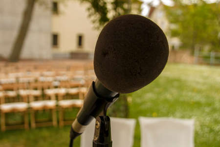 Wedding scenery with empty chairs and a black microphone in frontの写真素材