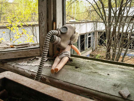 Doll with a gas mask on a window board in the ghost town Pripyat in the Chernobyl Exclusion Zone which was established after the nuclear disaster in 1986の写真素材