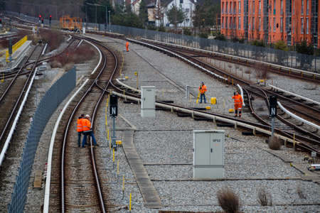 Railroad workers near the railway station of Froettmaning in Munich standing on the tracks