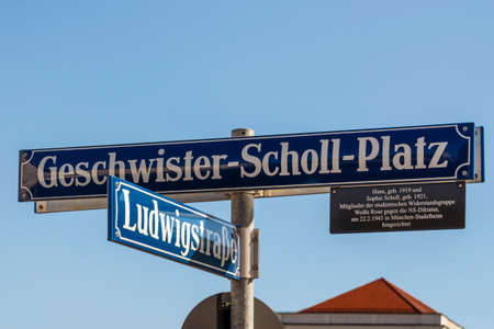 Street sign of the Geschwister-Scholl-Platz (Siblings Scholl Plaza) in front of the main building of the Ludwig Maximilian University of Munich, the name honors the founding members of the White Rose  resistance movementのeditorial素材