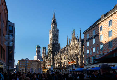 Marienplatz also called Mary's Square with the new city hall is one of the most vital places in Munich and unidentified people are walking alongのeditorial素材