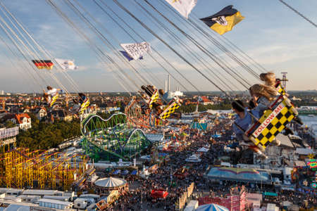 Munich, Germany - September 24, 2016: Carousel in motion with people flying through the air on Theresienwiese above the Oktoberfest fairgroundのeditorial素材
