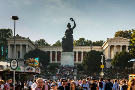 Munich, Germany - September 24, 2016: The Bavaria is a monumental, bronze sand-cast 19th-century statue with the hall of fame in the background, the statue is located at Theresenwiese in Munich, picture was taken during Oktoberfestのeditorial素材