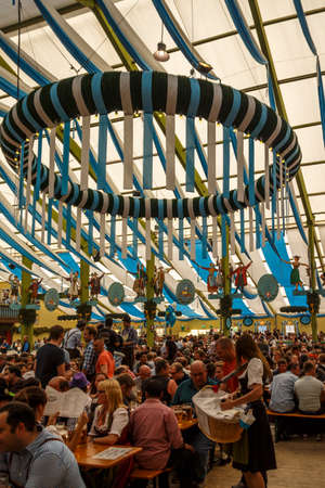 Munich, Germany - September 24, 2016: Inside the Ochsenbraterei beer tent at Oktoberfest with people celebrating and drinking beerのeditorial素材