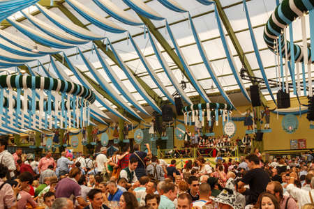 Munich, Germany - September 24, 2016: Inside the Ochsenbraterei beer tent at Oktoberfest with people celebrating and drinking beerのeditorial素材