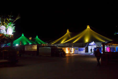 Munich, Germany - November 30, 2016: Tollwood winter festival and christmas market in Munich during the evening hours with illuminated tents and barsのeditorial素材