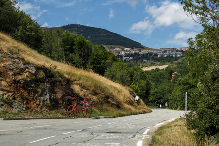 L'Alpe d'Huez, France - August 19, 2019: Ascent of the famous climb to L'Alpe d'Huez and itinerary of the Tour de France, pictured is the red bicycle close to the Eglise Saint-FerrÃ©ol churchのeditorial素材
