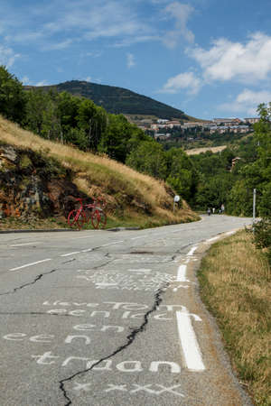 L'Alpe d'Huez, France - August 19, 2019: Ascent of the famous climb to L'Alpe d'Huez and itinerary of the Tour de France, pictured is the red bicycle close to the Eglise Saint-FerrÃ©ol churchのeditorial素材