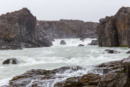 churned water between dark rocksの写真素材