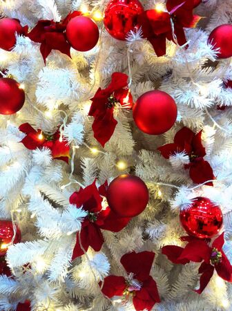Red balls hanging on white christmas treeの素材