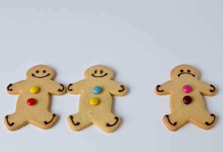 Three shortbread figures demonstrate that three is often a crowdの写真素材