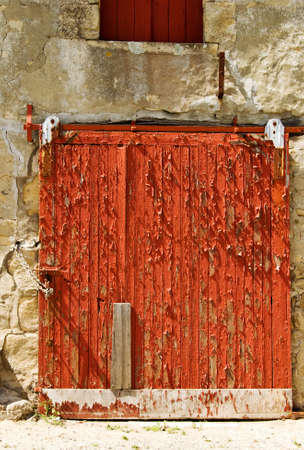 The texture and pattern of peeling red paint on a doorの写真素材