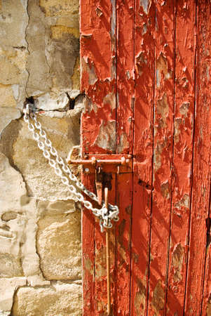 The texture and pattern of peeling red paint on a doorの写真素材