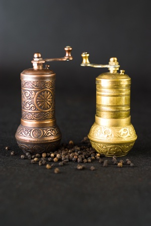 Vintage still life with brass pepper mill standing on the grey backgroundの写真素材