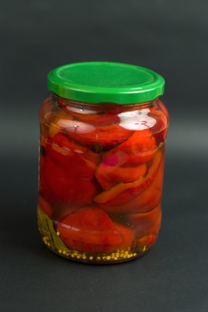 Canned red pepper in the glass on the black backgroundの写真素材