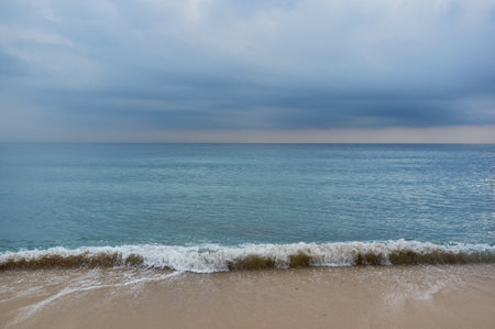 Cloudy seascape on a golden sandy beach on Tarifa coast before storm. Natural minimalist backgroundの写真素材