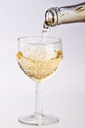 Pouring white wine into a glassの写真素材