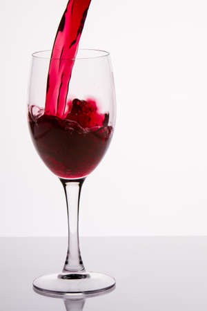 Pouring red wine into a glassの写真素材