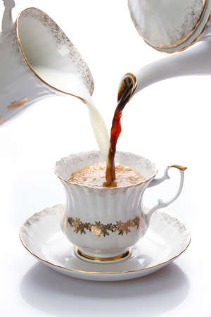 Milk and coffee poured in a cupの写真素材
