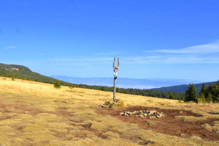 Mountain landscape with a metal pole on the top of the mountainの写真素材