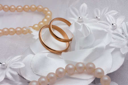 Two wedding rings and pearl on wedding background の写真素材