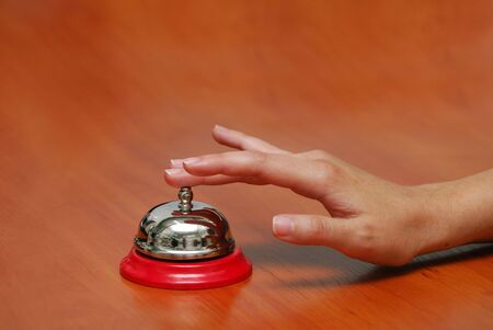 bright hand-bell on a table, hand press buttonの写真素材