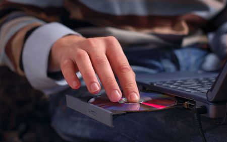 inserting disc in  laptop disk drive. blu-ray mediaの写真素材