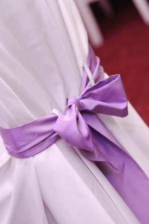 Violet ribbon decoration on wedding chairs cover.の写真素材