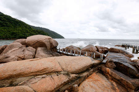 sea waves crash on the rocks in coast of Palmas island in santos, sao paulo state, brazilのeditorial素材
