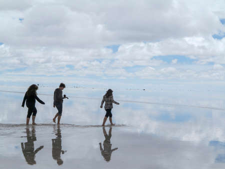 Salar de Uyuni, Bolivia - jan 26, 2014  - panorama of the perfect white flat salt desert with blue cloudy sky with  group of young peopleのeditorial素材