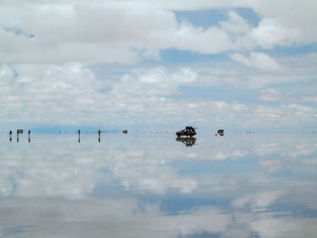 Salar de Uyuni, Bolivia - jan 26, 2014  - Off road car on the perfect white flat salt desert with blue cloudy sky.のeditorial素材