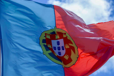 Portugal flag , blowing in the wind with blue sky on background