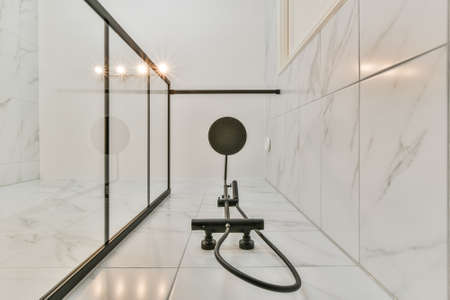Bottom view of the beautiful shower head in a bright luxury bathroom with marble walls