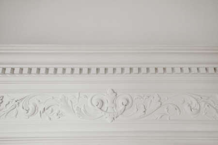 Decorative clay stucco relief molding with ornaments on white ceiling in abstract classical style interiorの写真素材