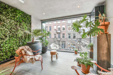 Elegant room with a balcony with various plants and beautiful chairsの写真素材