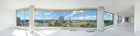 Beautiful view of city from the window in a large spacious corridor. Panoramic shot of empty apartment with large windowsの写真素材