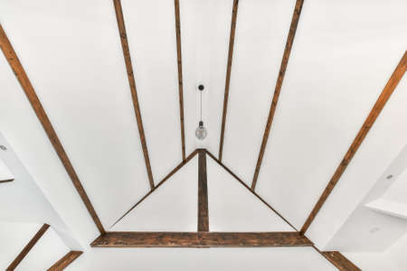 Ceiling with wooden beams in a house with white walls