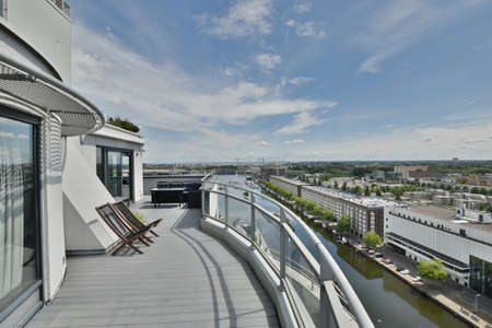 Spacious balcony with excellent view of city buildings and riverの写真素材