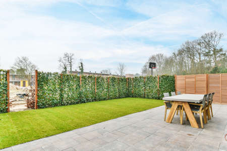 Beautiful backyard terrace full of furniture and decorative plantsの写真素材