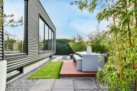 Beautiful backyard terrace full of furniture and decorative plantsの写真素材