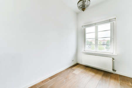 Modern counters with stools placed on wooden floor near electric fireplace in spacious room with...