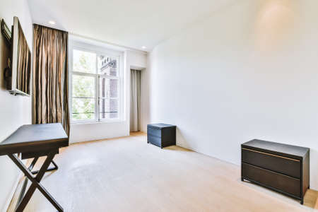 Interior of spacious room with chests of drawers in apartment designed in minimal styleの写真素材