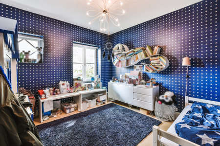 Interior of modern kid bedroom with bed and shelves with various toys at home