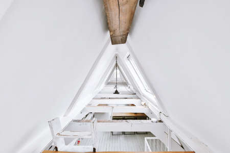 Open plan studio apartment with triangle shaped roof and construction of wooden beams in daylightの写真素材