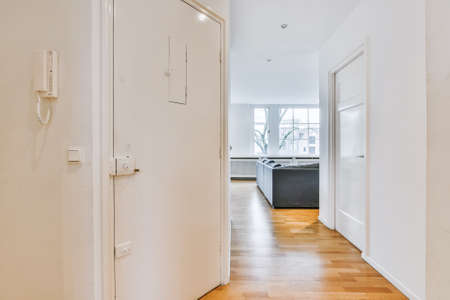 Interior of modern hallway with white doors located near light living room in contemporary apartment