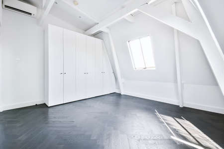 Interior of spacious empty room with white walls and geometric elements in contemporary cottage in minimal styleの写真素材