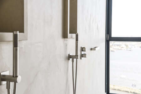 Shiny silver chrome wall mount mixer of shower set and minimalist nozzle in holderの写真素材