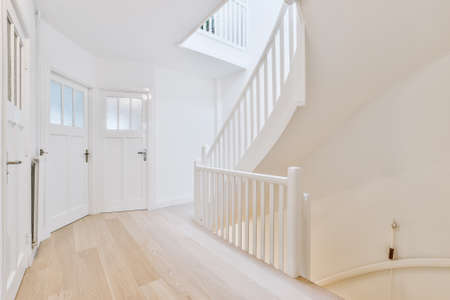 Hall with wooden floor and white walls with glass paned doors and staircase leading up and down