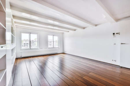 Interior of spacious room with empty shelves and wooden floor in modern apartmentの写真素材