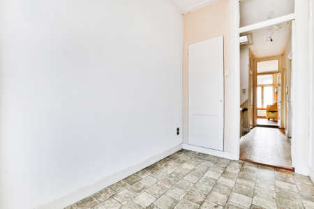 Fragment of interior of empty room with tiled floor and closet door in old fashioned apartment with...